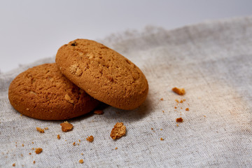 Pile of oat cookies on homespun napkin, close-up, selective focus.