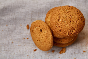 Pile of oat cookies on homespun napkin, close-up, selective focus.