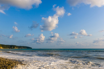 sea landscape is a pebbly beach with waves in white foam
