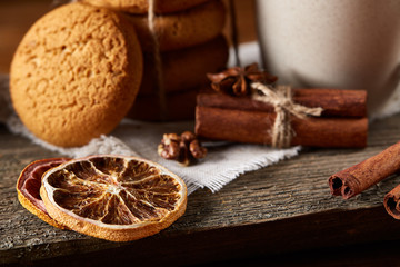 Traditional Christmas tea concept with a cup of hot tea, cookies and decorations on a wooden table, selective focus