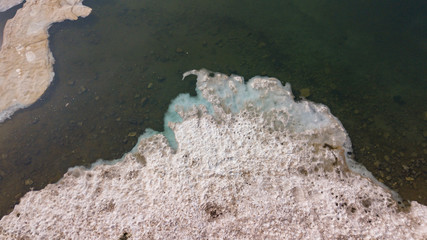 Ice and snow melting in a mountain lake during the spring season. Italian Alps
