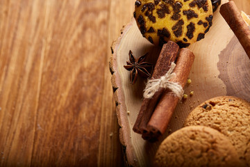 Sweet assortment of biscuits on a round wood log over rustic wooden background, close-up, selective focus.