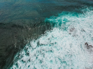 Aerial view from a surf spot with waves and a group of surfers in Ericeira, Portugal