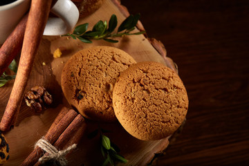 Sweet assortment of biscuits on a round wood log over rustic wooden background, close-up, selective focus.
