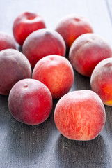 ripe homegrown peaches on black wooden table