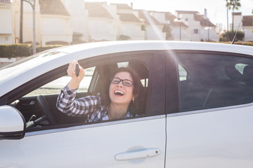 Attractive young happy woman shows keys from the new car