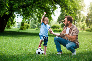 Obraz premium happy father and son showing yes sign after playing football at park