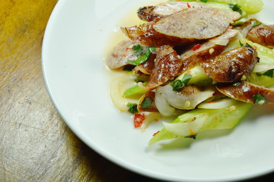 spicy slice Chinese pork sausage with cucumber Thai salad on white plate