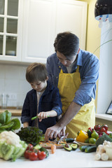 father and son cooking salad