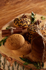 Sweet assortment of biscuits on a round wood log over rustic wooden background, close-up, selective focus.