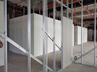 Drywall installation work in progress by construction workers at the construction site. It is the...