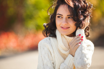 Young beautiful woman at autumn background. Portrait of attractive young girl outdoors