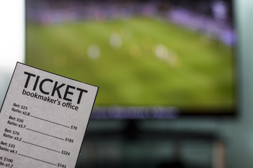 The World Cup is on the TV in the hands of a ticket office bookmaker, sports betting, close-ups
