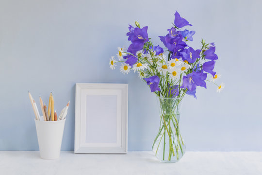 Mockup with a white frame and summer blue flowers