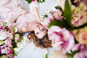 Beautiful young woman with make-up and curls. The girl's face is in flowers.
