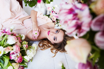 Beautiful young woman with make-up and curls. The girl's face is in flowers.