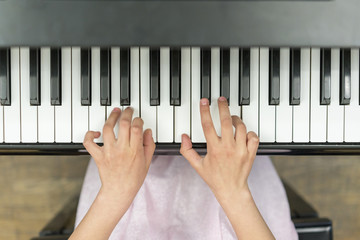 Hands on piano keys close-up. Closeup girl's hand playing piano. Favorite classical music. Top view...