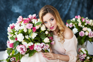 Beautiful young woman with make-up and curls. The girl's face is in flowers.