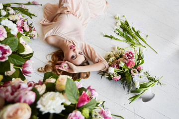 Beautiful young woman with make-up and curls. The girl's face is in flowers.