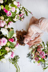 Beautiful young woman with make-up and curls. The girl's face is in flowers.