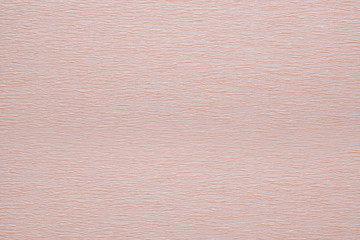 Texture of corrugated crepe paper of light beige pink color, abstract background 
