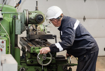 The old mechanic works at the lathe