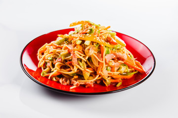 noodles with bacon, pepper and sesame seeds on a red plate on a white background. Traditional Italian pasta. Close