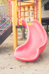 Pink slider tunnel in playground,vintage filtered.