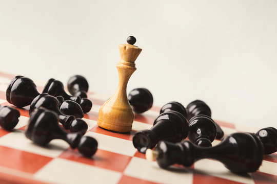 White chess queen beats blacks on chessboard