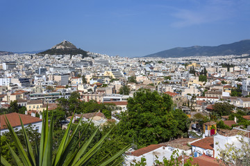 Greece, Athens, Lycabettos: Sunset panorama view of famous popular Mount Lycabettus hill in the city center of the Greek capital with skyline horizon and blue sky in the background.