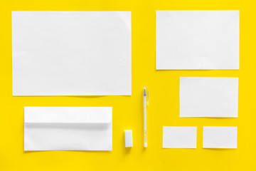 Blank stationery for branding, envelopes on yellow background top view mockup pattern