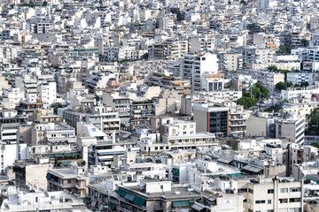 Fototapeta premium Greece, Athens: Skyline with mass of houses, buildings, apartments, rooftops in the city center of Greek capital - concept urban development town planning structure living condition.