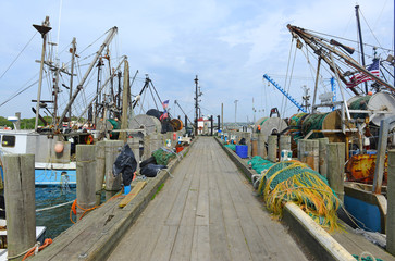 Naklejka premium maritime scene with commercial fishing boats near dock before sailing into the ocean