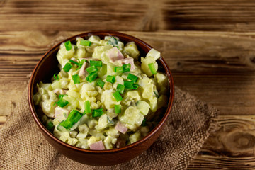 Traditional Russian festive salad Olivier on wooden table