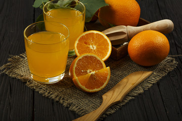 Obraz na płótnie Canvas Fresh orange juice with mint in a glass bowl on a dark plate. Orange juice on a dark background, top view, copy space.