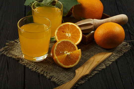 Fresh orange juice with mint in a glass bowl on a dark plate. Orange juice on a dark background, top view, copy space.