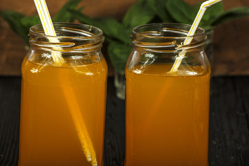 Fresh orange juice with mint in a glass bowl on a dark plate. Orange juice on a dark background, top view, copy space.