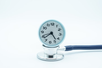 close up of vintage round clock on Stethoscope on white background. Health Care and time concept.