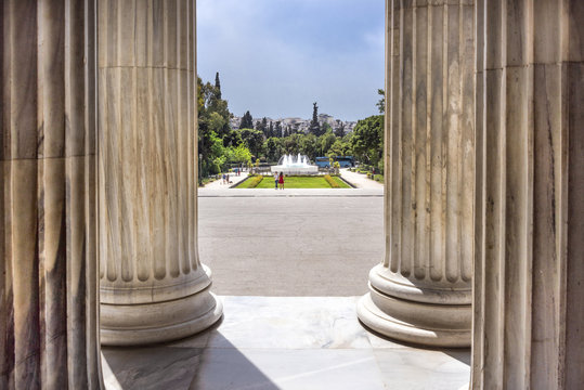 Greece, Athens: View from main entrance of famous Zappeion building in the city center of the Greek capital and part of National Gardens with people, and lue sky in the background. April 29, 2018