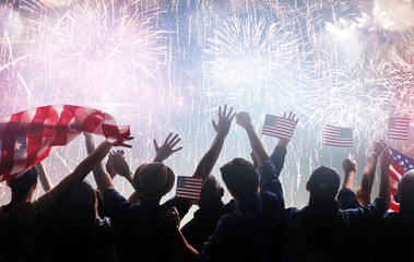 Silhouettes of people holding the Flag of the USA.