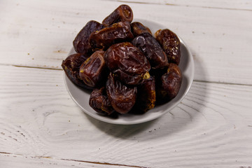 Dried dates fruit on white wooden table