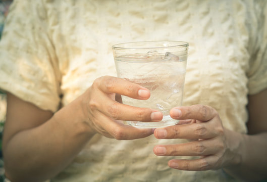 Woman hold glass of cold water.