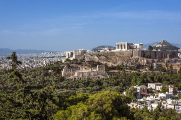 Fototapeta na wymiar Greece, Athens: Panoramic skyline view of famous Acropolis with Parthenon, Erechtheum, Temple of Athena in the city center of the Greek capital and blue sky in the background - concept travel panorama