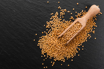 fresh grains of mustard on a rustic background