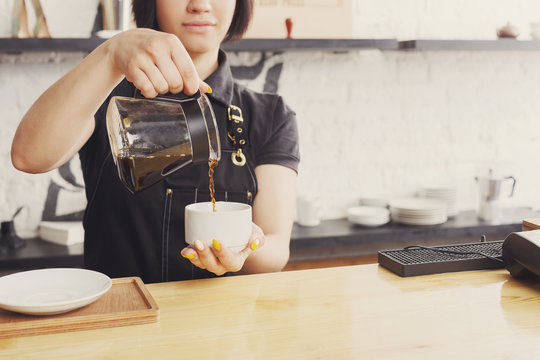 Portrait of young barista at coffee shop counter
