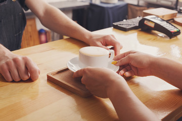 Fototapeta na wymiar Barista serving coffee cup on wooden bar counter
