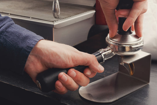 Closeup of barmen hand brewing espresso in cafe