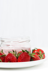 sweet fruit yogurt in a glass jar and fresh strawberries, vertical
