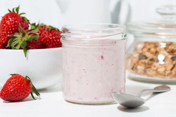 sweet strawberry yogurt, granola and fresh berries on white table, closeup