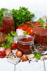 tomato sauces, pasta and fresh ingredients on white wooden background, vertical top view